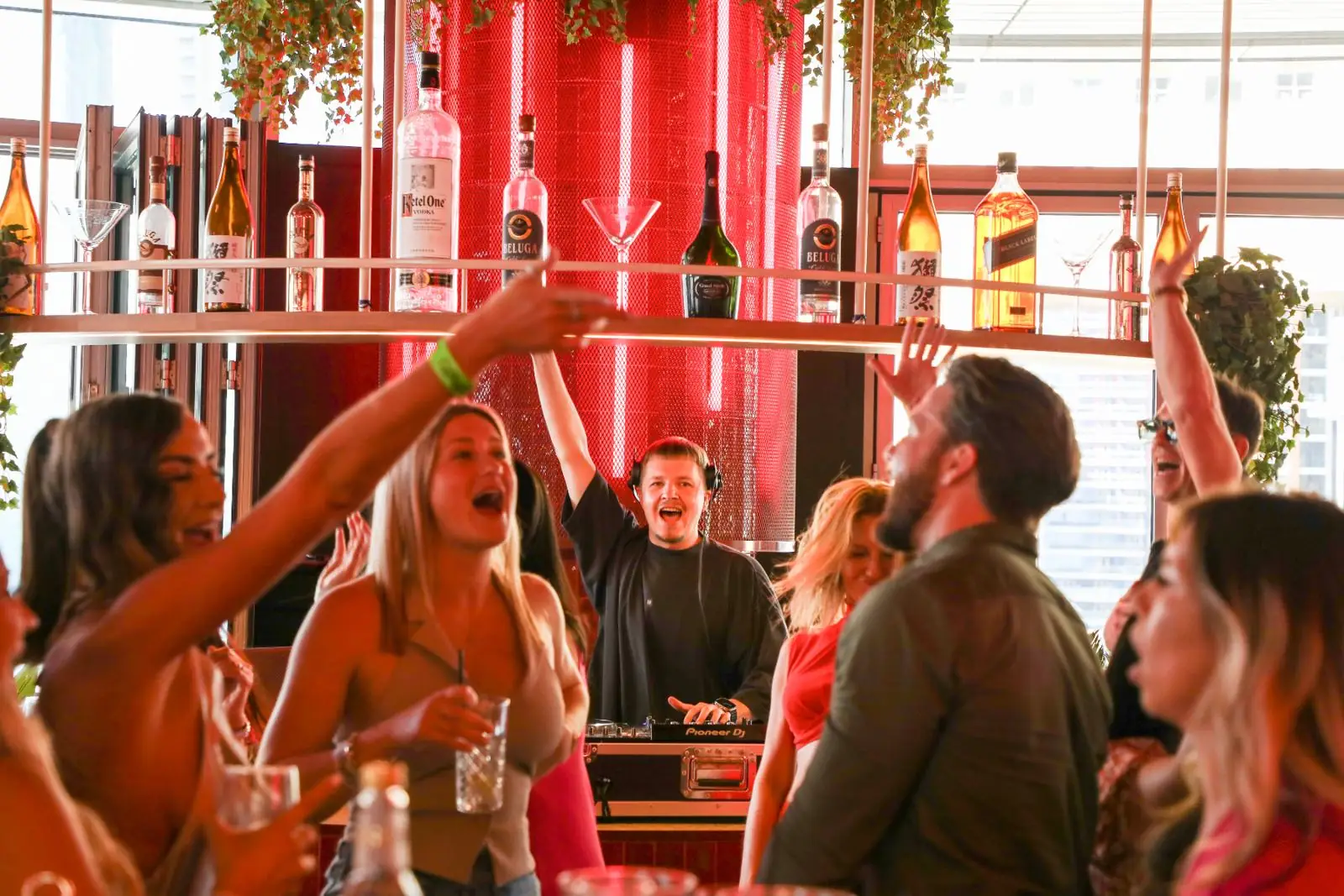 Guests dancing at the bar with the DJ behind